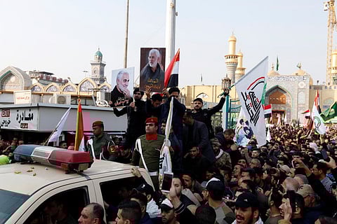 Mourners gather around the car which carries the coffins of the Iranian Major-General Qassem Soleimani and the Iraqi militia commander Abu Mahdi Al Muhandis, who were killed in a US air strike at Baghdad airport on Friday.