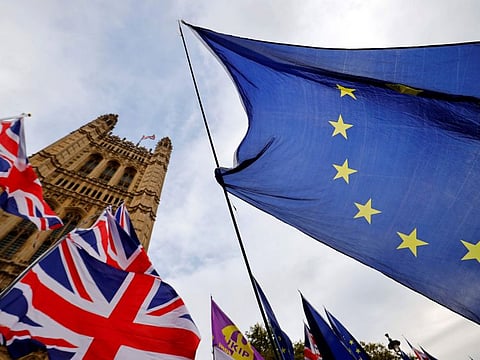 Anti-Brexit activists' EU flags are pictured alongside the Union flags of pro-Brexit activists as they demonstrate outside of the Houses of Parliament in London.