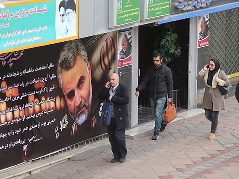 Pedestrians walks past portraits of slain Iranian military commander Qasem Soleimani in a main thoroughfare of the Iranian capital Tehran on January 4.