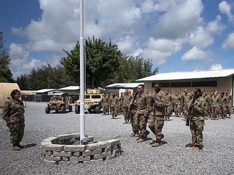 In this photo taken Aug. 26, 2019 and released by the U.S. Air Force, airmen from the 475th Expeditionary Air Base Squadron conduct a flag-raising ceremony, signifying the change from tactical to enduring operations, at Camp Simba, Manda Bay, Kenya. The al-Shabab extremist group said Sunday, Jan. 5, 2020 that it has attacked the Camp Simba military base used by U.S. and Kenyan troops in coastal Kenya, while Kenya's military says the attempted pre-dawn breach was repulsed and at least four attackers were killed. (Staff Sgt. Lexie West/U.S. Air Force via AP)