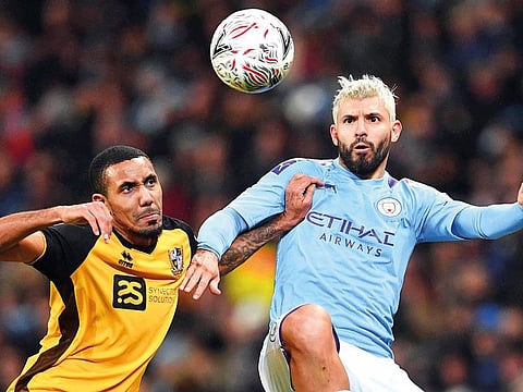 Sergio Aguero (right) of Manchester City is being challenged by a Port Vale defender during their FA Cup clash on Saturday.