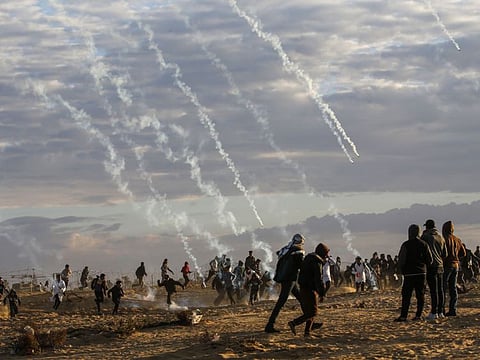 Tear gas canisters are fired by Israeli forces at Palestinians during a protest near the Israel-Gaza border fence, east of Rafah in the southern Gaza Strip, on December 27, 2019.