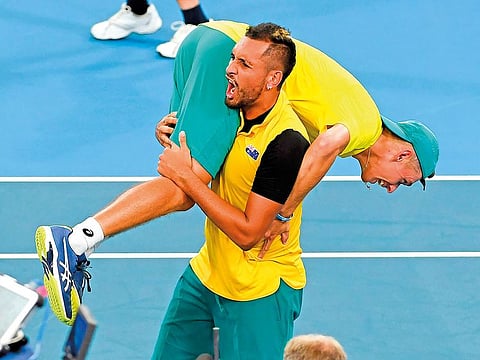 Nick Kyrgios carries teammate Alex de Minaur after Australia defeat GB in the ATP Cup.