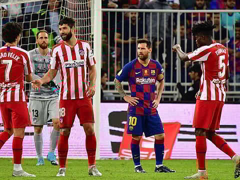 Barcelona's Lionel Messi looks dejected at Atletico Madrid celebrate.