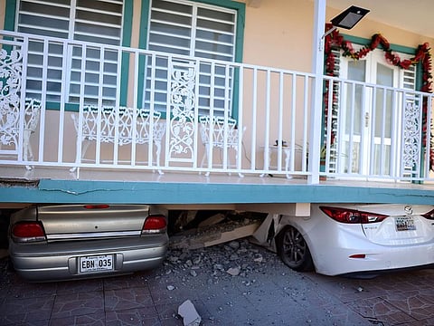 Cars are crushed under a home that collapsed after an earthquake hit Guanica, Puerto Rico, Monday, Jan. 6, 2020