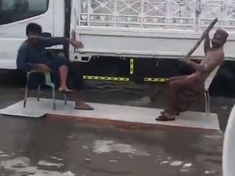 A wooden plank with two chairs used to raft through a waterlogged in the UAE