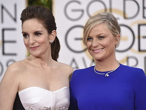 In this Jan. 11, 2015 file photo, Tina Fey, left, and Amy Poehler arrive for the 72nd annual Golden Globe Awards in Beverly Hills, California.