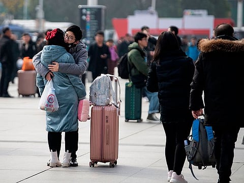Two people embrace as they arrive at a train station in the city of Wuhan in Hubei province on January 12, 2020