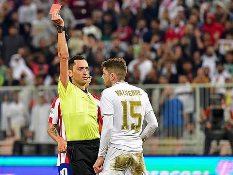 Jose Maria Sanchez Martinez shows Real Madrid's Federico Valverde a red card during the Spanish Super Cup final against Atletico Madrid at the King Abdullah Sports City in Saudi Arabia.