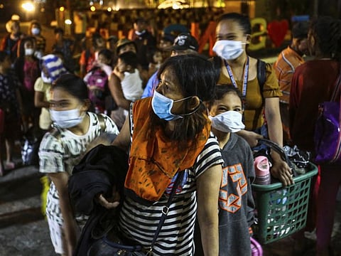 Residents of Talisay Town in Batangas arrive at the Sto Tomas Central School after being evacuated from the heavy ashfall and debris from the Taal Volcano eruption on Monday.