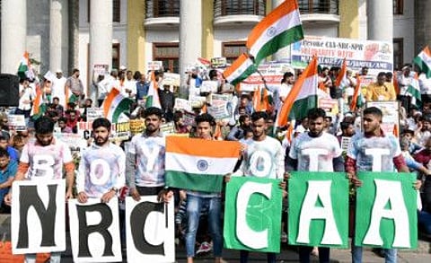 People hold tricolors and placards during a protest against India's CAA in front of Town Hall in Bengaluru