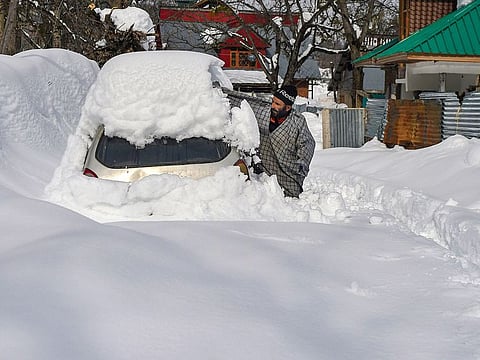 A man clears snow from his vehicle after heavy snowfall at Ferozpora village of Tangmarg in Baramulla district of north Kashmir.