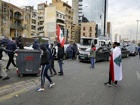 Anti-government protesters block a main highway by garbage containers in Beirut, Lebanon, Friday, Jan. 17, 2020.