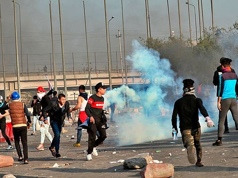 Security forces fire tear gas to disperse anti-government protesters during clashes in central Baghdad, Iraq, Monday, Jan. 20, 2020.