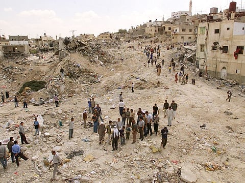 Palestinians search for their dead and retrieve some belongings after an Israeli attack on the Jenin refugee camp on April 18, 2002.
