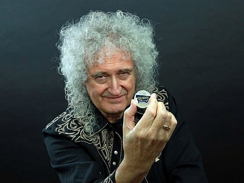 Guitarist Brian May of band Queen poses with a 5-pound coin.