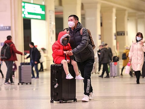 Commuters wearing face masks walk in Hankou railway station in Wuhan, in China's central Hubei province on January 21, 2020. Global markets were seen rebounding on Wednesday after China unveiled measures to contain the spread of a new strain of coronavirus.