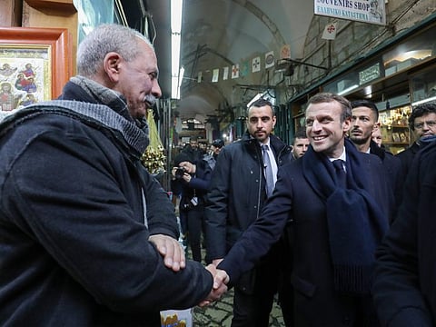 French President Emmanuel Macron greets a local as he tours the Old City of occupied Jerusalem on January 22.