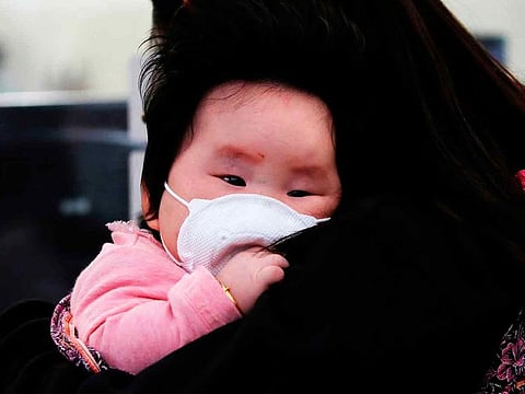 A child wears a mask to prevent an outbreak of a new coronavirus at the Hong Kong West Kowloon High Speed Train Station, in Hong Kong, China January 23, 2020.