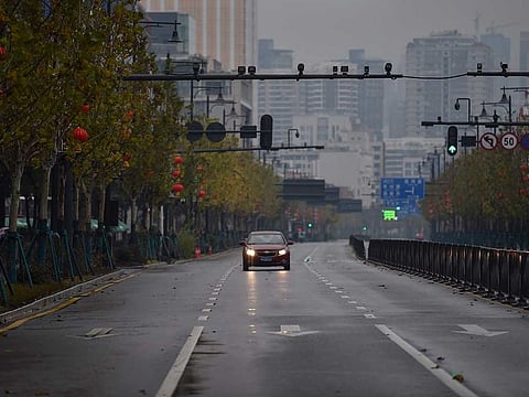 A lone car drives down a disserted street in Wuhan. China expanded drastic travel restrictions to contain the viral contagion, as the United States and France prepared to evacuate their citizens from the quarantined city at the outbreak's epicentre.