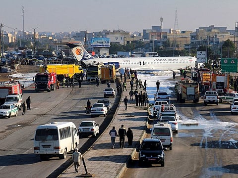 An Iranian passenger plane sits on a road outside Mahshahr airport after skidding off the runway, in southwestern city of Mahshahr