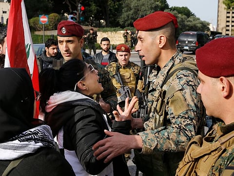 Army soldiers scuffle with anti-government protesters blocking a road leading to the parliament building in Beirut, Lebanon, Monday, Jan. 27, 2020. Lebanese security forces scuffled Monday with protesters near the parliament building in downtown Beirut, where lawmakers are scheduled to begin a two-day discussion and later approval of the state budget amid a crippling financial crisis.