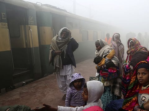 People wait for a train at Lahore station during a foggy morning in Pakistan on January 17, 2020. The Pakistan Supreme Court has summoned top railway officials in a case related to monetary loss.