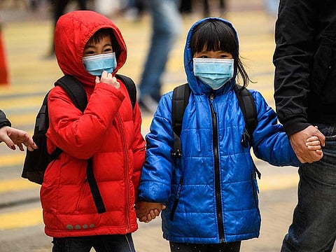 Children wearing face masks cross a road during a Lunar New Year of the Rat public holiday in Hong Kong.