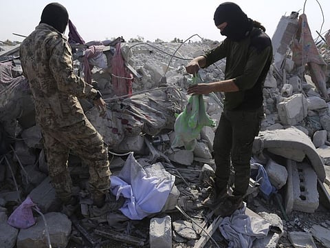 In this October 27, 2019, file photo, people look at a destroyed houses near the village of Barisha, in Idlib province, Syria, after an operation by the US military which targeted Abu Bakr Al Baghdadi, the Daesh leader.