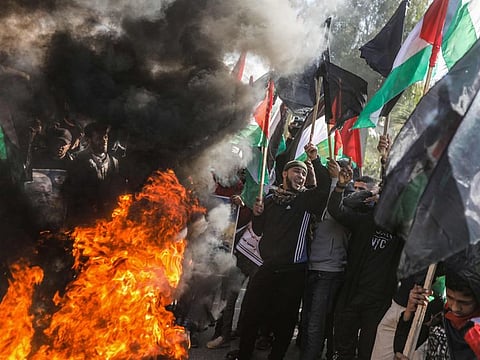 Palestinian demonstrators chant slogans and wave Palestinian flags as they stand by flaming tyres during a protest against US President Donald Trump's expected peace plan proposal in Gaza City on January 28.