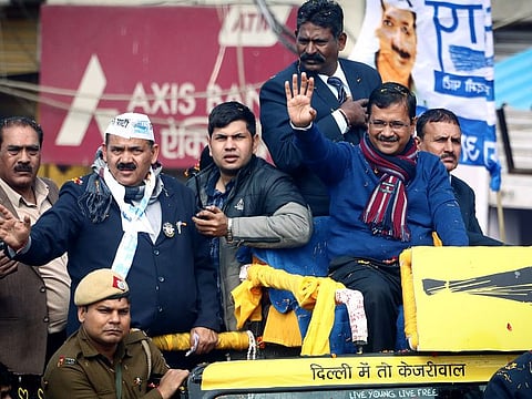 Delhi Chief Minister Arvind Kejriwal waves to supporters during a roadshow ahead of the forthcoming Delhi Assembly elections at Gokalpuri in New Delhi on Tuesday.