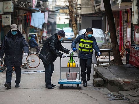 Government workers spray disinfectant along a street in Wuhan in central China's Hubei Province, Tuesday, Jan. 28, 2020. Hong Kong's leader announced Tuesday that all rail links to mainland China will be cut starting Friday as fears grow about the spread of a new virus.