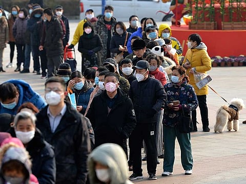 People line up to buy face masks at a drug store in Nanjing in eastern China's Jiangsu Province.