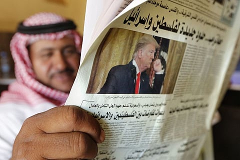 A man reads the daily Asharq Al-Awsat newspaper fronted by a picture of President Donald Trump, at a coffee shop in Jiddah, Saudi Arabia, Wednesday, Jan. 29, 2020.
