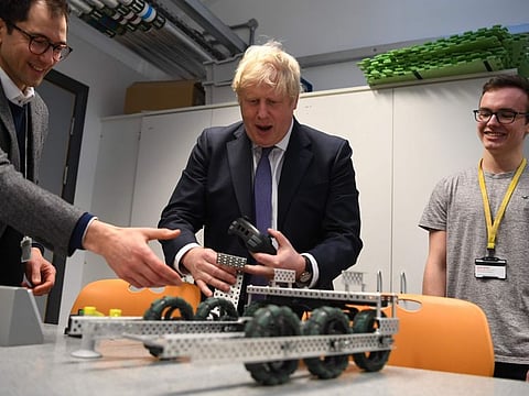 Britain's Prime Minister Boris Johnson (C) reacts after he crashed a robot built by students during his visit to the Department of Mathematics at King's Maths School, part of King's College London University, in central London on January 27, 2020. Britain on Sunday announced a new fast-track visa scheme for top scientists, researchers and mathematicians as it prepares a new immigration system for life outside the European Union. Johnson revealed the plan just days before Brexit finally takes place on January 31.
