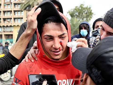 An anti-government protester, who was shot with an air rifle by police, is taken to receive first aid during clashes with security forces in Baghdad, Iraq, Wednesday, Jan. 29, 2020.