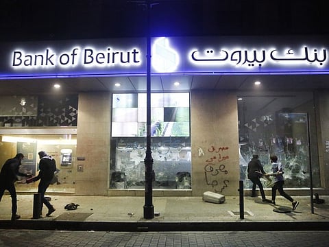 Anti-government protesters smash bank widows, during protests against the deepening financial crisis in Beirut, Lebanon