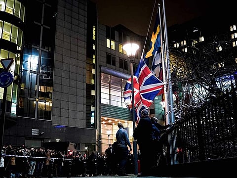 People take down the United Kingdom's flag from outside the European Union Parliament in Brussels,on Brexit Day, January 31, 2020