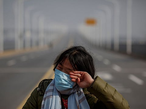 A mother reacts as she pleads with police to allow her daughter to pass a checkpoint for cancer treatment after she arrived from Hubei province at the Jiujiang Yangtze River Bridge in Jiujiang