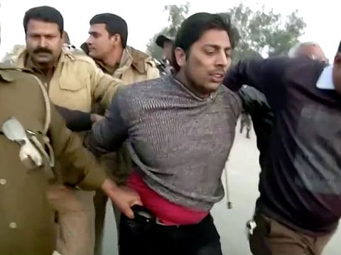 Police officers detain a man, who identified himself as Kapil Gujjar, who fired multiple shots at a site where people were protesting against a new citizenship law in New Delhi, India, February 1, 2020, in this still image taken from video.