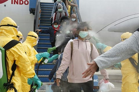 Indonesian students are disinfected as they disembark at the Hang Nadim international airport in Batam, following their evacuation from the Chinese city of Wuhan due to the coronavirus outbreak.