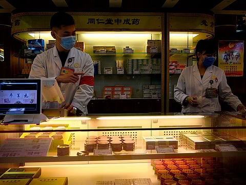 Employees wearing protective face masks at a traditional Chinese medicine store in Beijing.