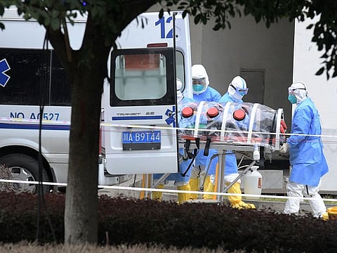 Medical workers in protective suits lift an isolated patient from an ambulance as the country is hit by an outbreak of the new coronavirus, in Chengdu, Sichuan province, China February 2, 2020.