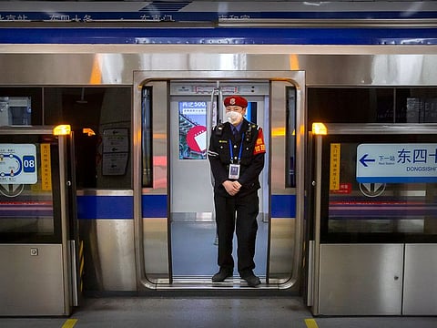 A security officer wearing a face mask stands on a subway train in Beijing.