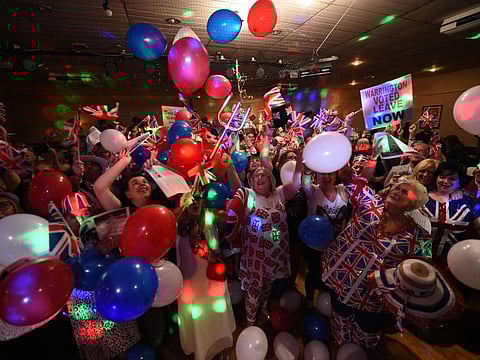 TOPSHOT - Brexit supporters wave Union flags as the time passes 11 O'Clock at a Brexit Celebration party at Woolston Social Club in Warrington, north west England on January 31, 2020, the moment that the UK formally left the European Union. Britain on January 31 ends almost half a century of integration with its closest neighbours and leaves the European Union, starting a new -- but still uncertain -- chapter in its long history. / AFP / Oli SCARFF