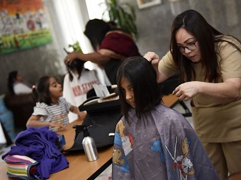 Volunteers get their hair cut for donation at the hair donation event for World Cancer Day at the Consulate General of India in Dubai on 4th February, 2020.