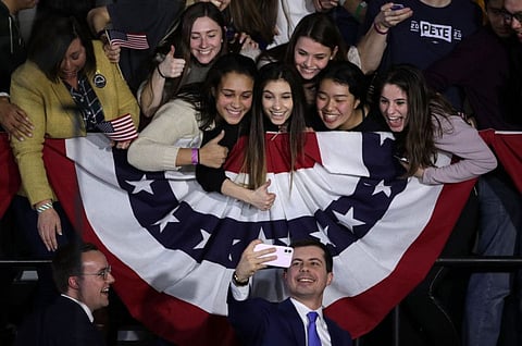 Chasten and Pete Buttigieg pose for a selfie with supporters at an election night rally in Des Moines, Iowa on February 3.