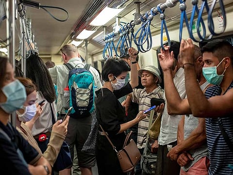 Commuters wear face masks to protect themselves from air pollution and the coronavirus on the BTS metro train in Bangkok, Thailand, Wednesday, Feb. 5, 2020.