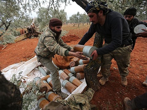 Syrian rebel fighters prepare to shoot a howitzer toward the government positions near the village of Nerab, in Idlib province, Thursday, Feb. 6, 2020.