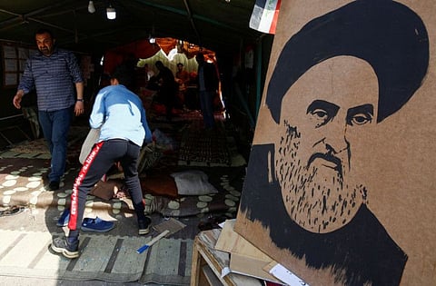 Iraqi demonstrators display a poster of Iraq's top Shiiite cleric, Ayatollah Ali Al Sistani outside the tent during ongoing anti-government protests in Najaf.